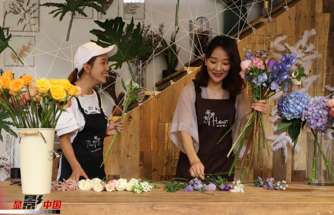 “昆明是鮮花的原產地，有亞洲最大的鮮切花交易市場，可以說具備開花店的天時地利；另外和很多女孩一樣，我從小也就有開花店的夢想！”說起當初的決定，王黎媛說一是因為夢想，另外也跟昆明這個城市產花、賣花的“基因”有關。圖為王黎媛和同事在制作花束。新華網 周亞平/攝 念新洪/文